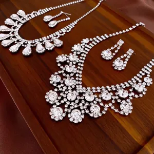 Luxury silver geometric tassel necklace set with sparkling crystals on dark wood display