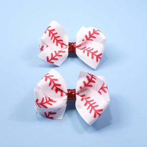 Detail of red baseball stitching ribbon bows with glitter centers on light blue background