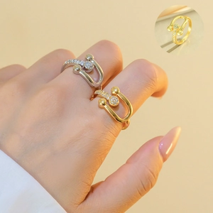 Close-up of U-shape gold and silver rings with pavé zircon stones on model's fingers