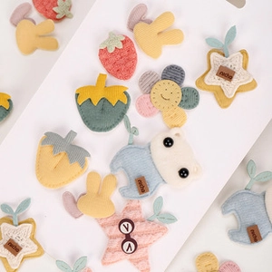 Detailed view of cute plush fabric patches in strawberry, star, and animal shapes.
