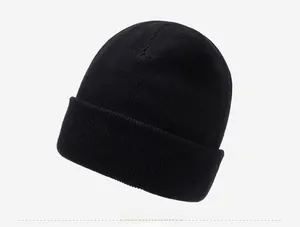 Side view of black ribbed knit beanie with thick fleece lining and metal logo plaque