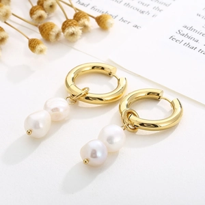Détail de boucles d'oreilles vintage en or avec anneaux géométriques et doubles perles