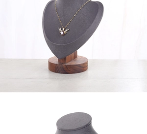 Detailed view of a gold reindeer antler necklace with purple gem on gray suede display
