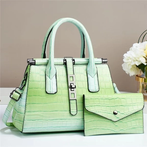Detail of mint green crocodile pattern handbag and matching envelope wallet set