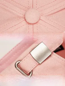 Vue détaillée de la casquette rose avec boucle métallique et coutures du bouton supérieur
