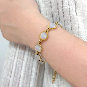 Detailed shot of a gold beaded bracelet with translucent lavender stones on a wrist