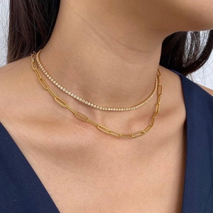 Close-up of layered gold tennis and paperclip link necklace on female model neck