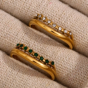 Zweilagige goldene Edelstahlringe mit klaren und grünen Zirkonia in einer Schmuckschatulle