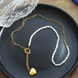 Elegant gold chain necklace featuring natural freshwater pearls and a heart pendant charm