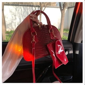 Detail of red crocodile pattern shell bag and mini pouch with golden hardware