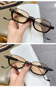 Detailed side view of black rectangular sunglasses with brown lenses and metal temples
