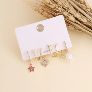 Detail of bohemian gold earrings set featuring crystal stars and heart studs on display card