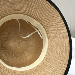 Gros plan de l'intérieur du chapeau de paille avec texture et cordons réglables