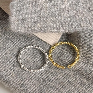 Macro shot of 925 sterling silver knotted braid rings in gold and silver finishes