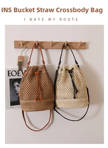 Detail of hollow woven straw bucket bags in brown and beige colors with drawstring closure