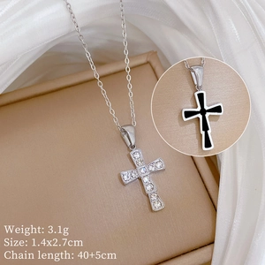 Detail view of silver titanium steel cross pendant with crystal inlay on a jewelry box