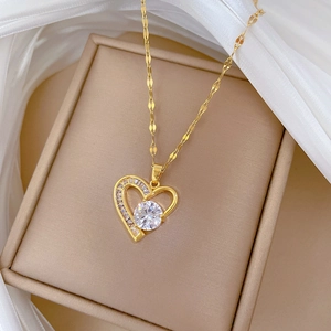 Close-up of gold heart necklace with crystals on silk background