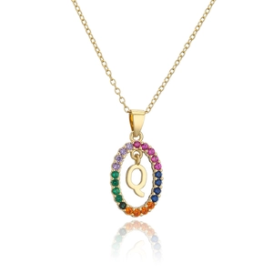 Detailed macro view of gold letter Q pendant with multicolored rainbow zircons stones