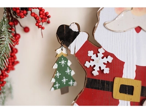 Dettaglio dell'ornamento in legno di Babbo Natale con texture dipinte e fiocchi di neve