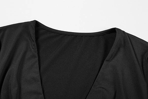 Close-up of deep V-neckline on a slim black dress featuring premium knit texture and stitching