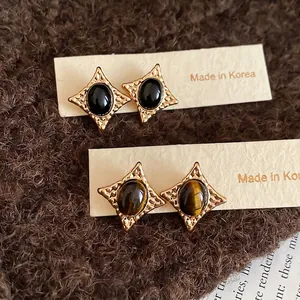 Retro starburst stud earrings with oval tiger eye stone and gold-plated textured finish