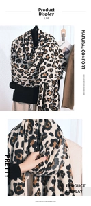 Detail of soft leopard print imitation cashmere scarf with tassels and fabric texture