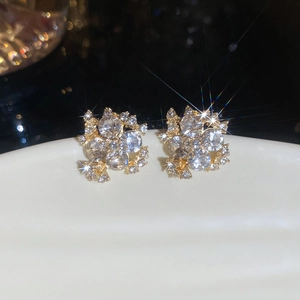 Macro shot of sparkling flower cluster stud earrings with gold plating and zircons