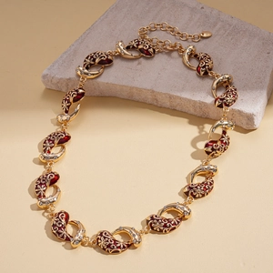 Detailed macro view of vintage gold necklace with red enamel petals and zircon accents