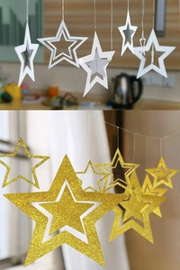 Close-up of hanging hollow star decorations with shimmering gold and silver glitter finish