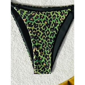 Detail of green and black leopard print bikini bottom with high-cut design and piping