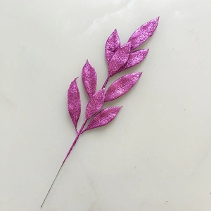 Detail of glittery purple artificial leaves for Christmas tree decoration on grey background