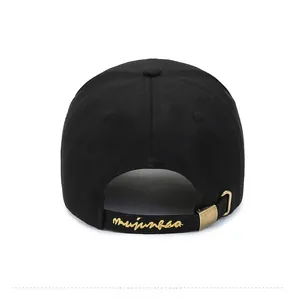 Detail of black baseball cap back with gold embroidery and adjustable metal buckle