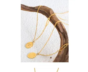 Close-up of gold plated chain necklace with Good Luck engraved oval pendant