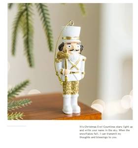 Close-up of a white and gold resin nutcracker soldier ornament with festive bokeh lights