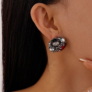 Detailed view of vintage gothic cluster stud earring with grey gem and red accents