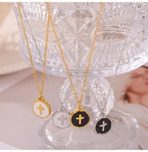 Detail of round cross pendants on gold and silver titanium necklaces with oil drip finish