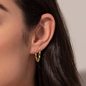 Close-up of a gold s925 sterling silver chain tassel earring with sparkling star zircon crystals