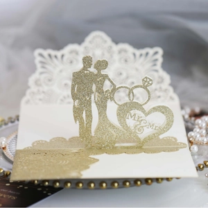 Golden laser-cut pop-up wedding invitation featuring Mr & Mrs silhouettes and rings