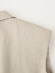 Detailed shoulder texture of a beige sleeveless vest suit featuring professional tailoring