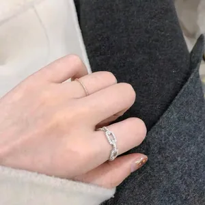 Sparkling silver eternity ring and zircon chain band shown worn on a hand in a close-up shot