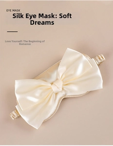 Detailed view of champagne silk eye mask featuring a large bow and soft elastic strap