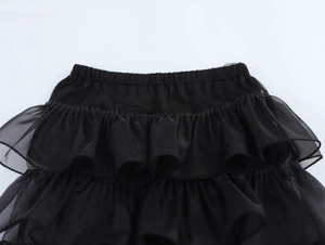 Dettagli di una gonna nera in tulle a balze multistrato con balze e vita elasticizzata