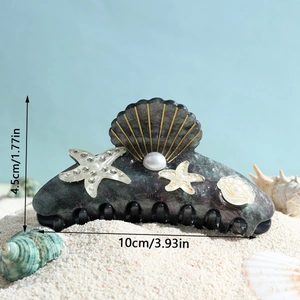 Iridescent ocean hair claw clip with starfish shell pearls and rhinestones on beach sand
