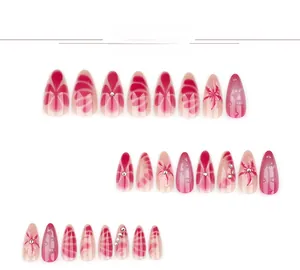 Détail de faux ongles amandes longs avec motifs floraux et strass dégradés roses