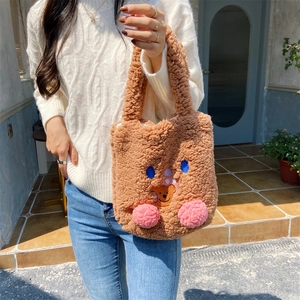 Detailed close-up of brown plush tote bag featuring cute cartoon bear embroidery