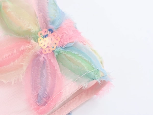 Makroaufnahme von bunten 3D Stoffblumen Stickereien und Pailletten auf rosa Rock