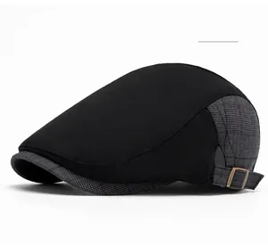 Detail of newsboy cap featuring side metal buckle and black grey plaid patchwork design
