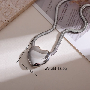 Macro detail of silver heart pendant with thick snake chain and product weight info