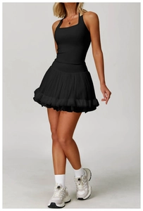 Detail of black sports set featuring a racerback top and layered ruffle tennis skirt
