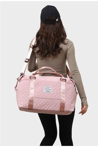 Pink quilted large capacity travel bag shown on a model to demonstrate size and carry style